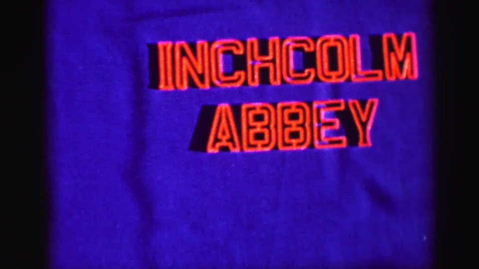 1950s-style 8mm title card with red Inchcolm Abbey lettering on a deep blue background.