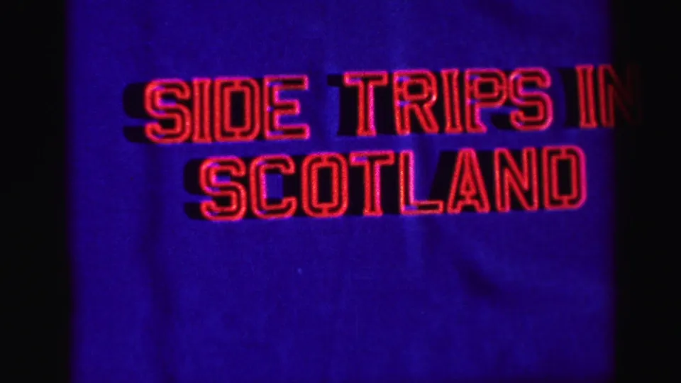 Home-movie title card for a Scottish travel segment, with red outlined lettering on a deep blue background.