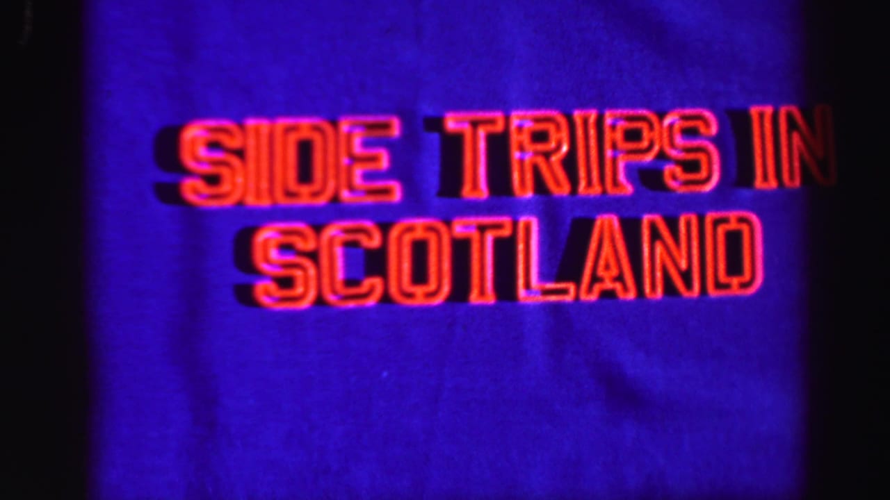 Projected-looking 8mm title frame showing “Side Trips in Scotland” in red lettering on a saturated blue background.