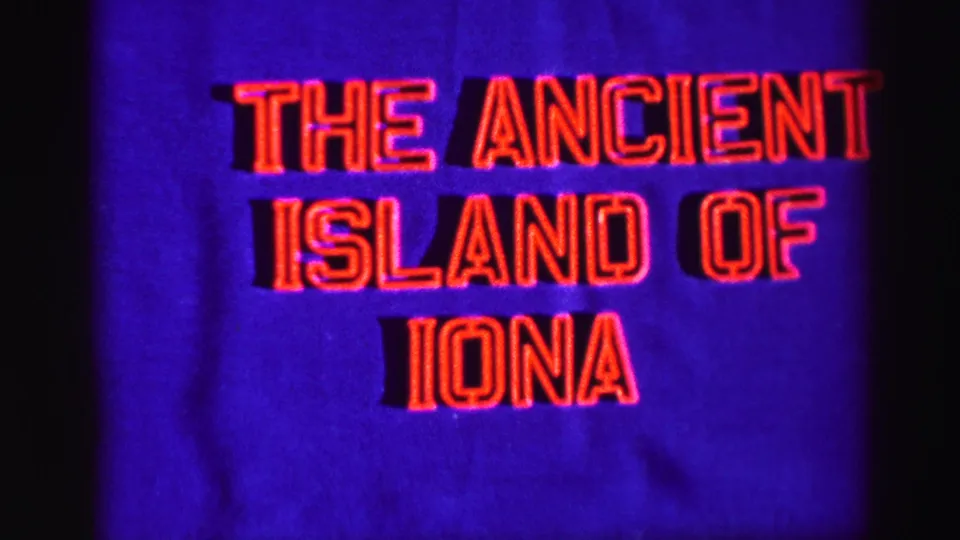 1952 travel-title frame reading “The Ancient Island of Iona,” photographed in red text over a blue field.