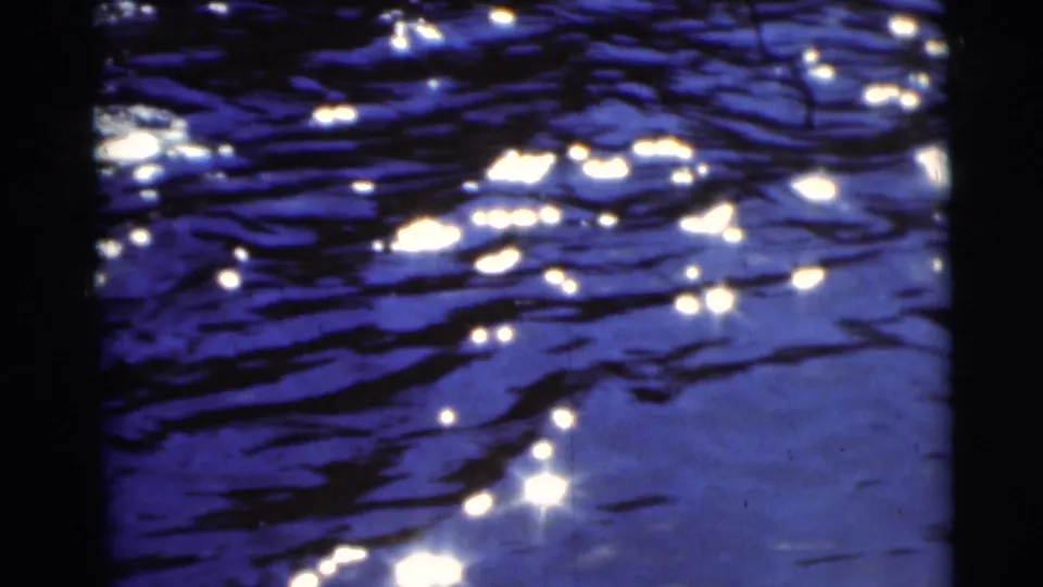 Blue water in Baraboo, Wisconsin catches bright sun glints, with ripples and shadowed edges in the 8mm frame.