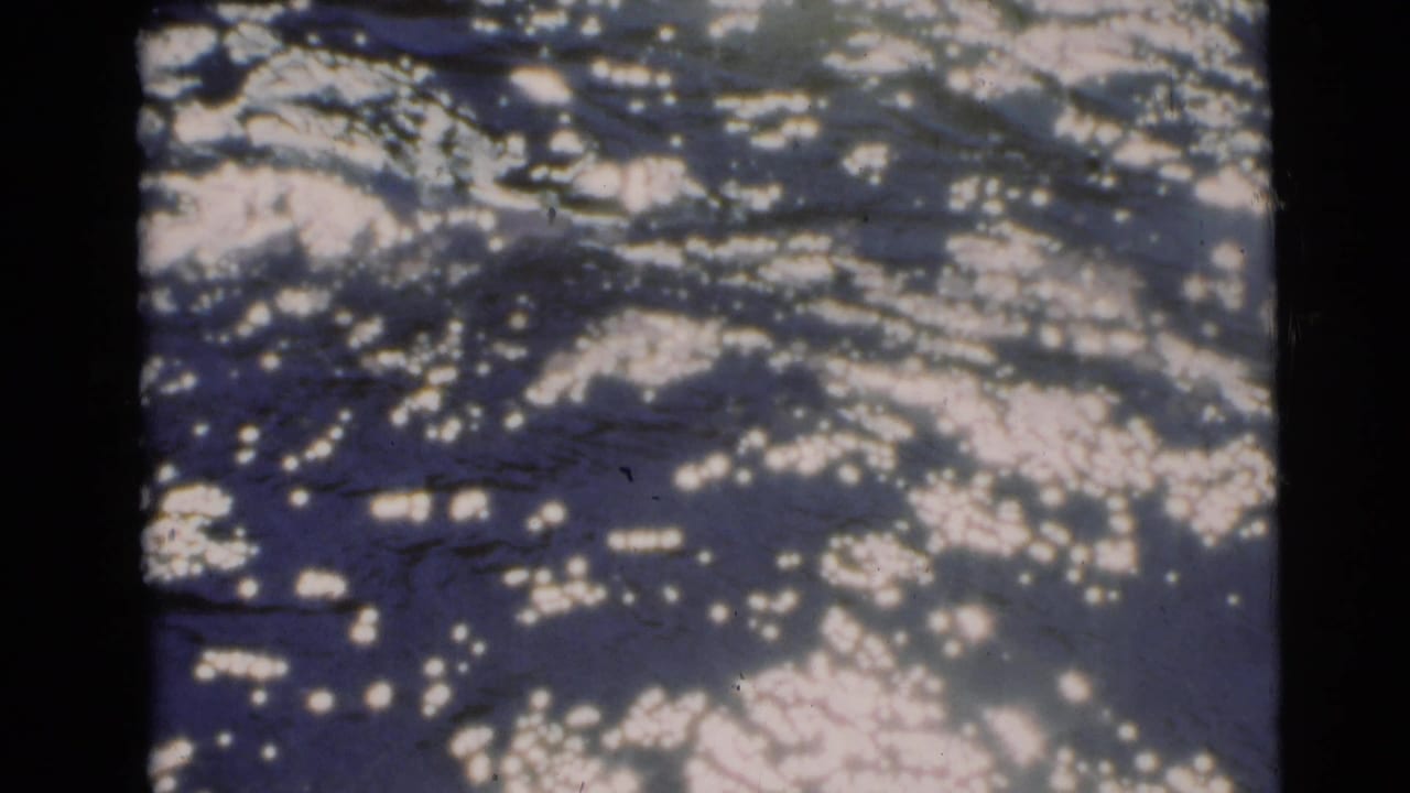 Bright rippled water seen through dark film edges.