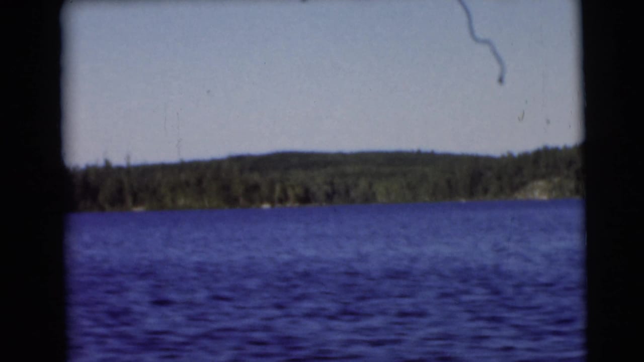 Baraboo-area lake footage from 1953 showing blue water, a low wooded horizon, and visible 8mm frame borders.