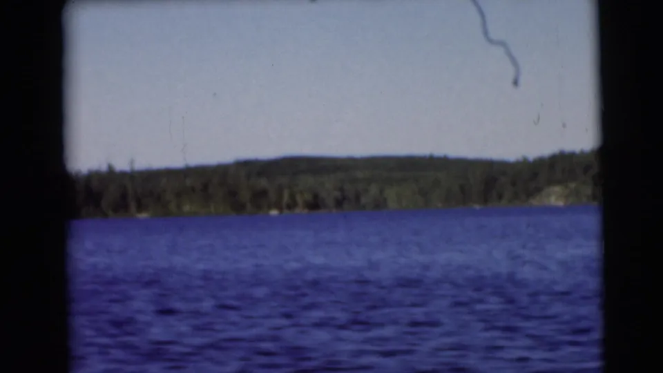 Baraboo-area lake footage from 1953 showing blue water, a low wooded horizon, and visible 8mm frame borders.