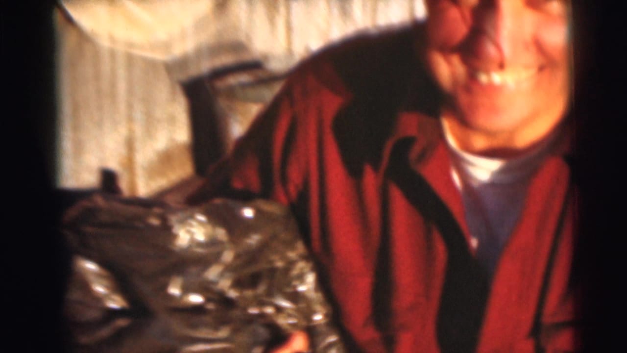 In 1953 Baraboo, Wisconsin footage, a smiling fisherman in a red jacket holds a catch near a wooden dock.