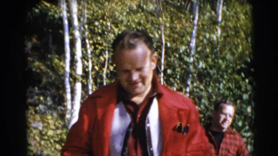 In the final frame, the red-jacketed man is closer to the camera, with the plaid-shirted man partly behind him in the wooded Baraboo scene.