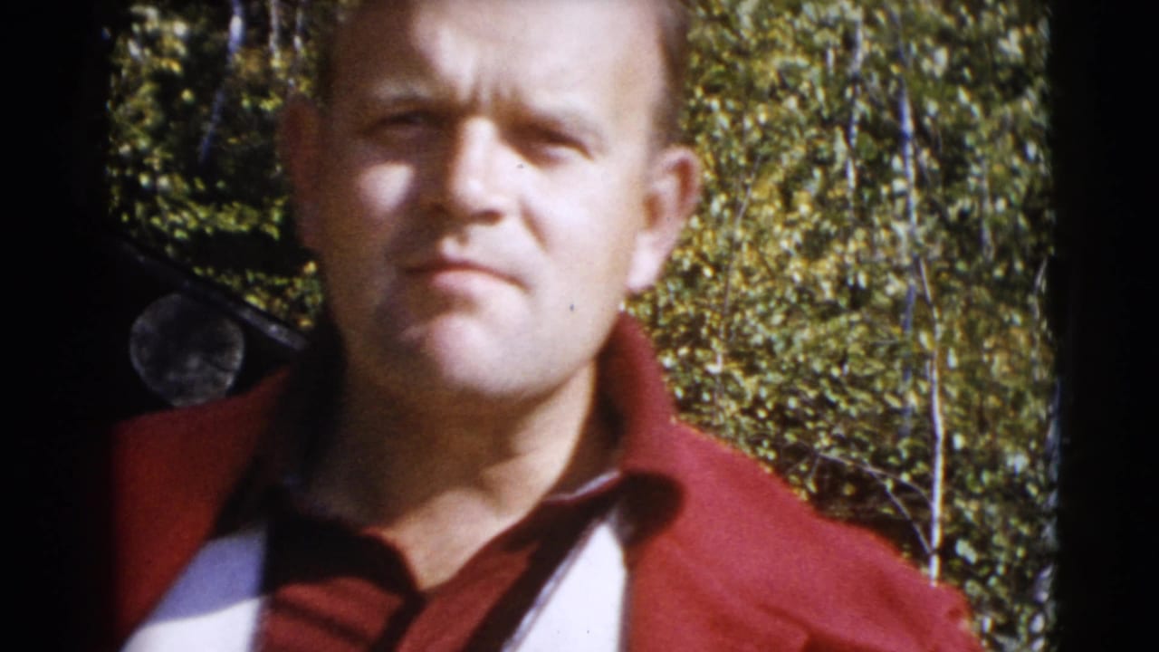 Close home-movie view of an adult man in a red jacket before a wooded background in 1953 Baraboo footage.