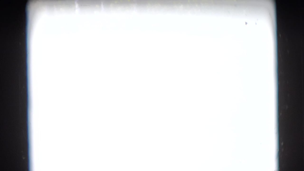 Mostly overexposed 8mm frame from the 1953 Baraboo home movie, with dark film edges and no clear subject visible.