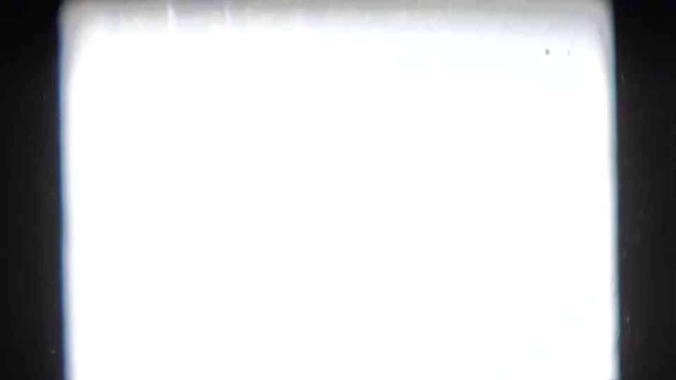Mostly overexposed 8mm frame from the 1953 Baraboo home movie, with dark film edges and no clear subject visible.