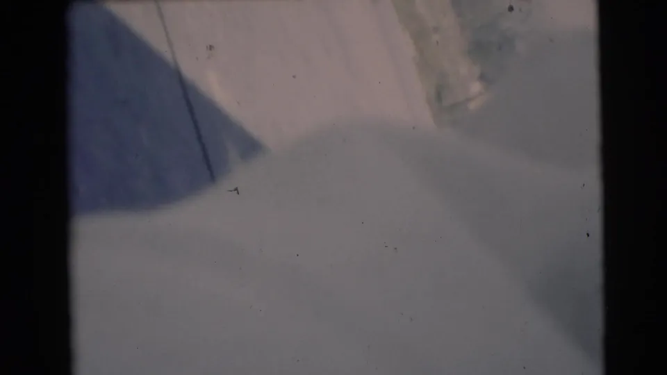 1953 Baraboo home-movie frame showing a light green blanket in sunlight, with the resting person still mostly hidden.
