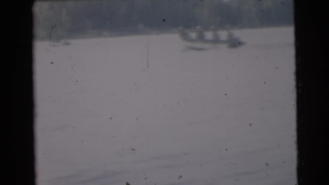 Soft, distant view of a lake with shoreline shapes and dark film borders.