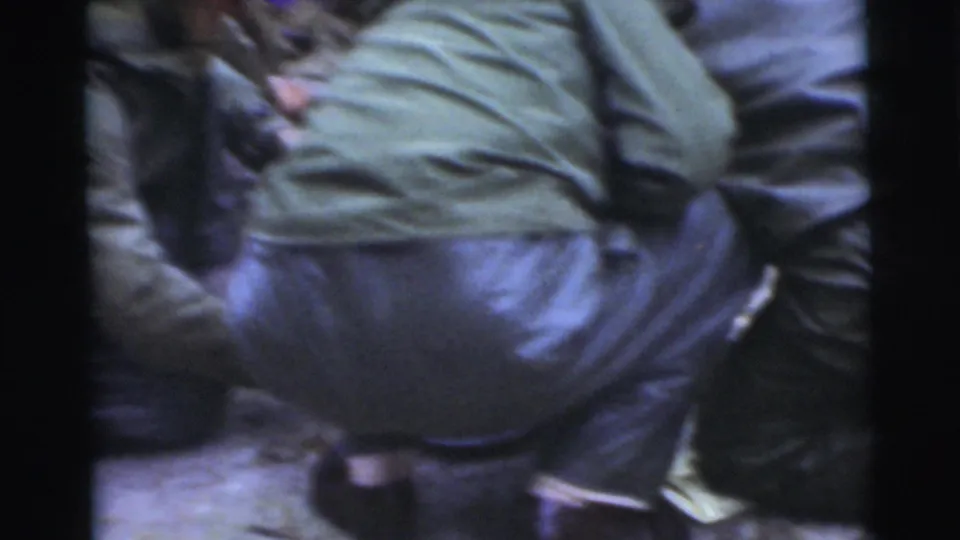 In the supplied 1956 Miami clip, men in heavy coats cluster tightly while the handheld camera frames them from close range.