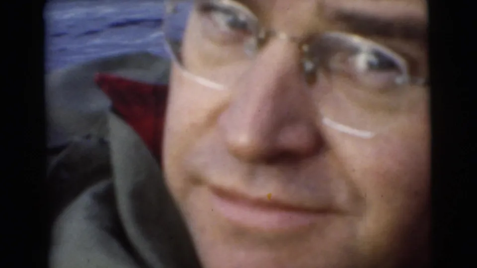 Close home-movie view of a man in glasses on a boat during a 1956 Miami lake outing.