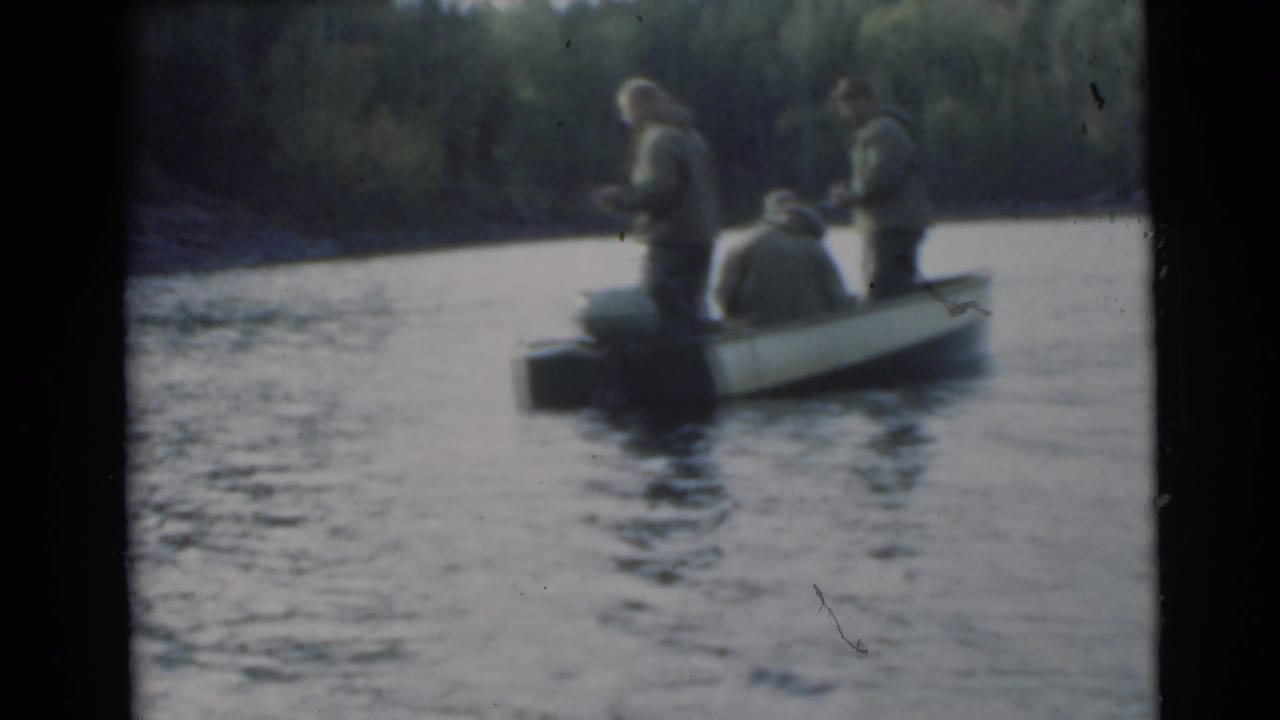 Small boat with three men fishing on calm lake water.