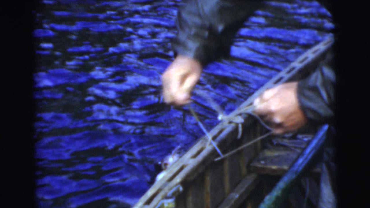 Hands handling fishing line and tackle over the side of a small boat.