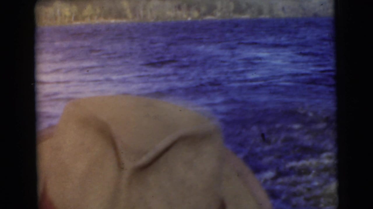 Close view of a light hat near blue water with a distant shoreline.