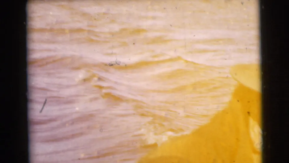 Overexposed warm 8mm frame showing rippling water texture, likely from the same 1956 Miami boat footage.