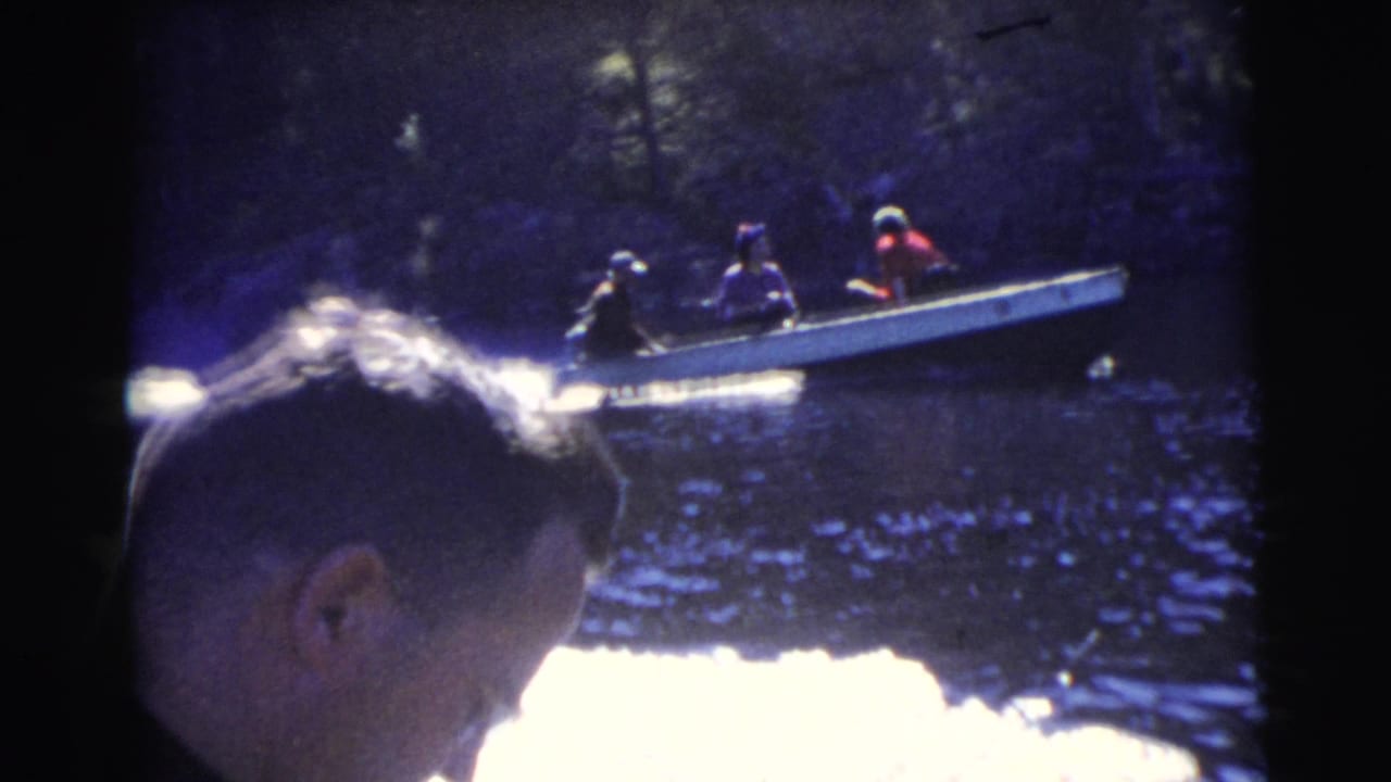 1956 Miami home-movie frame from one boat, with a man's head in the foreground and another small motorboat behind him.