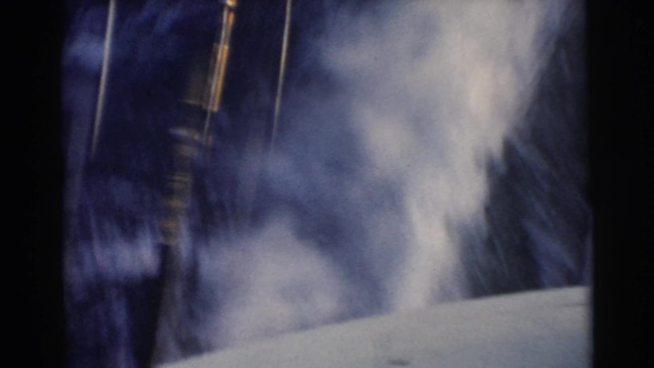 Blurred boat-side view with water spray and dark vertical film edges.