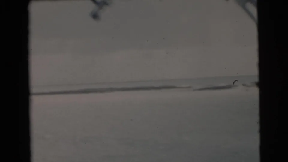 1956 Miami-area 8mm view from a boat, showing calm open water, a low horizon, and dark frame or window edges.