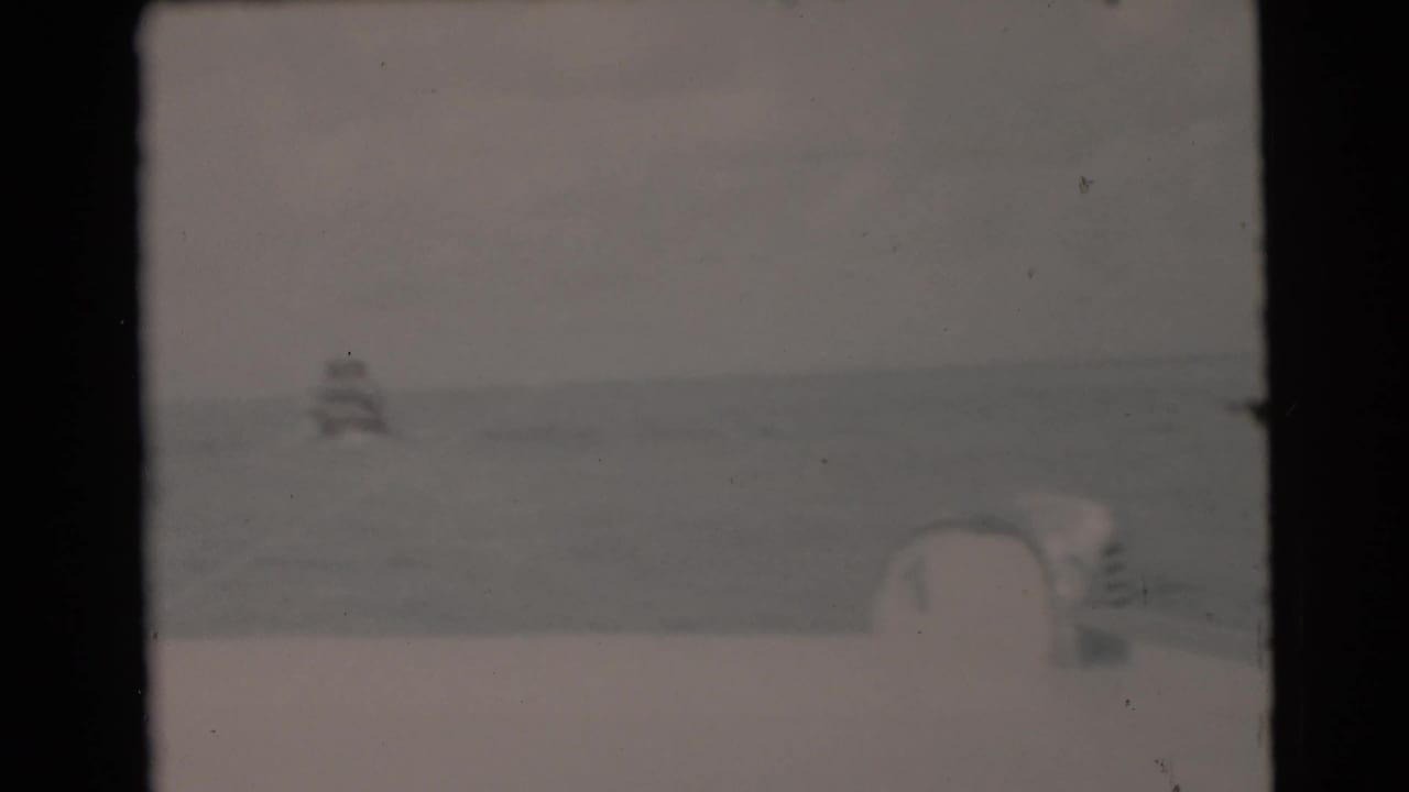 1956 Miami-area ocean view from a moving boat, with a faint small vessel near the horizon.