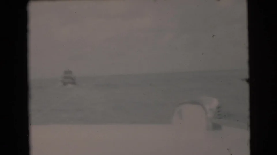 1956 Miami-area ocean view from a moving boat, with a faint small vessel near the horizon.