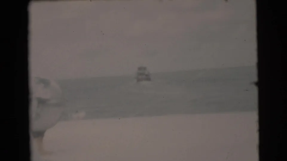 Soft 8mm Miami-area boating frame with open ocean, low deck foreground, and a small distant craft.