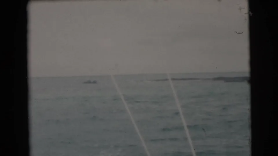 1956 Miami coastal footage shows rough water, distant craft, and pale fishing lines or rod guides in the foreground.