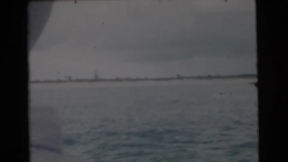 1956 Miami home-movie frame showing open river water and a low distant horizon from a moving boat.