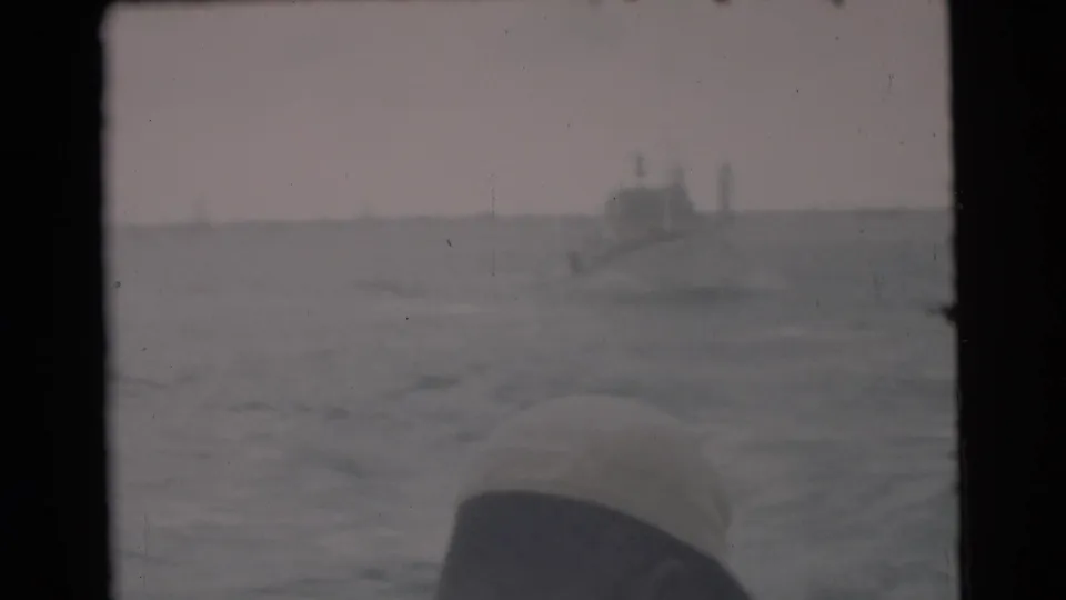 Hazy 1956 Miami 8mm ocean frame with a distant boat and a rounded foreground edge at lower right.