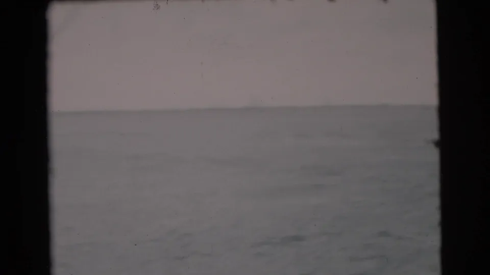 1956 Miami-area 8mm frame showing open ocean, low horizon, and muted overcast sky from a moving boat.