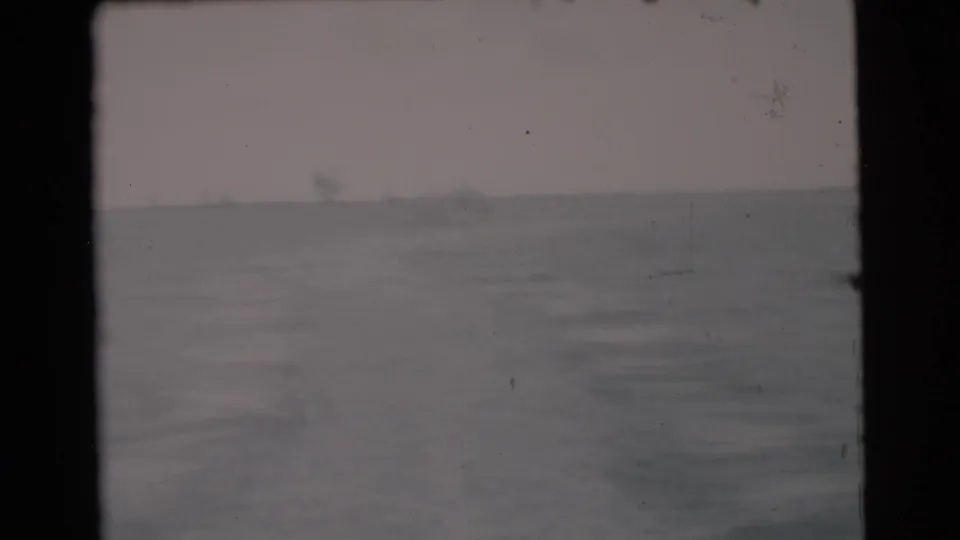 1956 Miami-area 8mm view of open water and a hazy horizon from a moving boat, with dark frame borders visible.