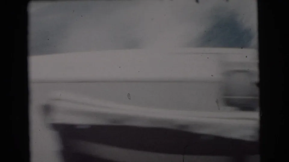 Soft 8mm frame from the 1956 Miami fishing trip showing the boat edge, rail, and water in motion-softened focus.