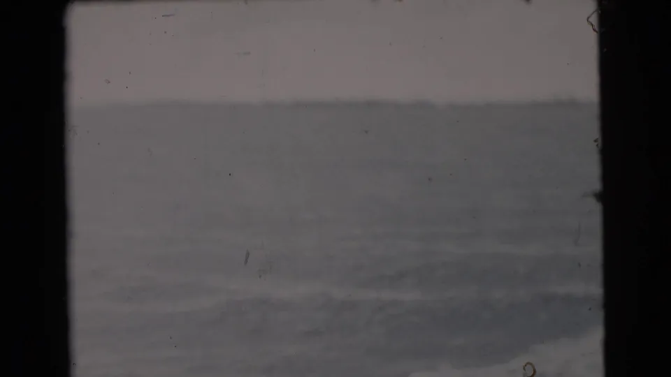 8mm frame of open water near Miami, with a faint horizon and subdued color from the aged film scan.