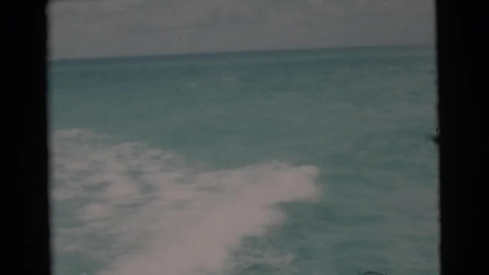 1956 Miami-area 8mm frame of open water and foamy wake, with a faint horizon and soft overcast light.