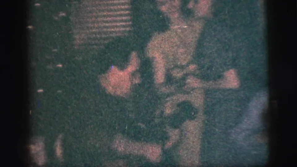 1956 New York City home-movie frame showing a couple dancing closely in a small, dimly lit venue.