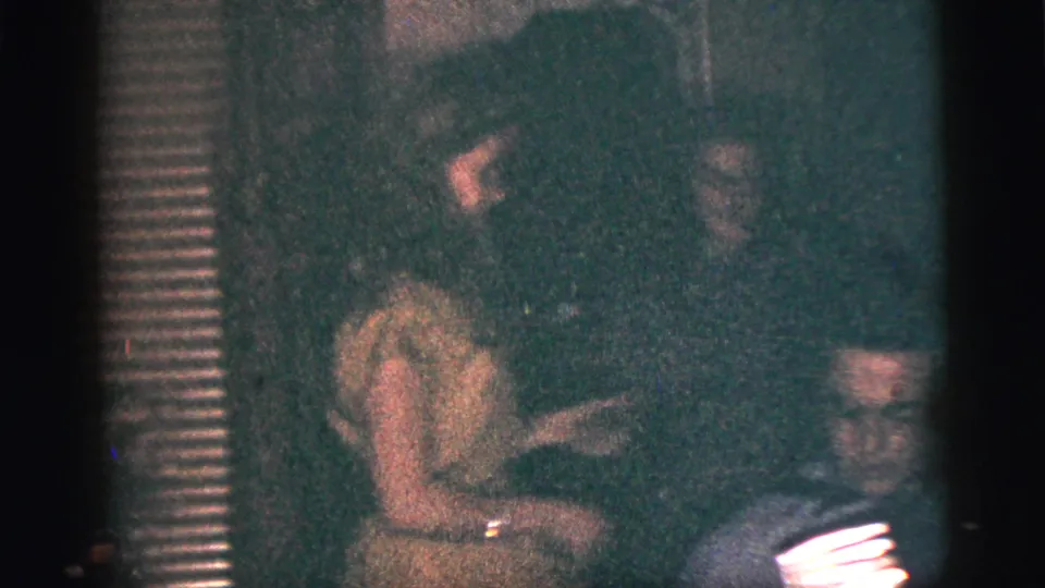 A young woman appears to dance near a seated accordion player during a 1956 New York City indoor gathering.