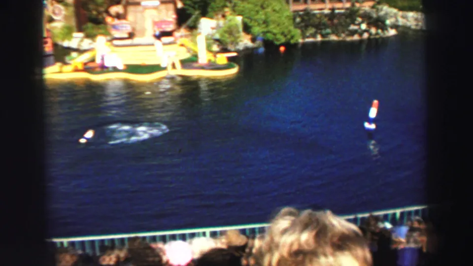 Visitor-shot Lake Tahoe water-show frame with floating props on the lake and a stage area beyond the water.