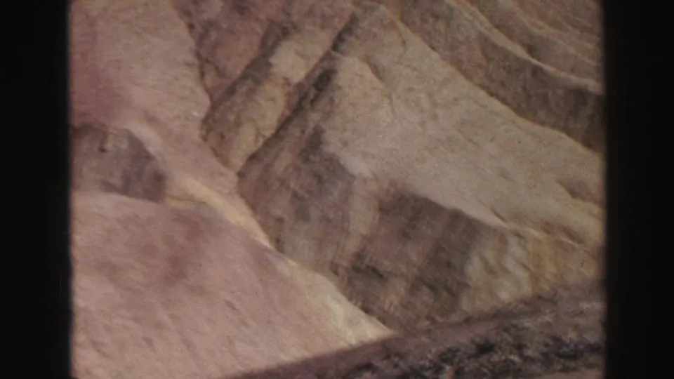 1969 Lake Tahoe-area 8mm frame showing warm-toned canyon rock faces, layered stone, and soft film grain.