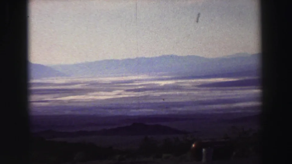 Wide 1969 Lake Tahoe view showing misty water, distant mountain ridges, and soft 8mm color shift.