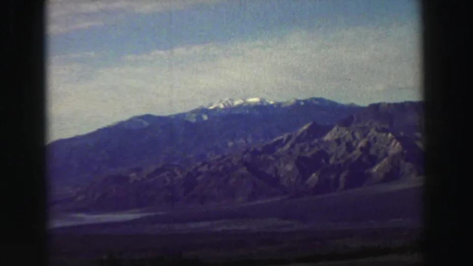 1969 8mm view across an arid valley toward distant snow-dusted mountains in the Lake Tahoe region.