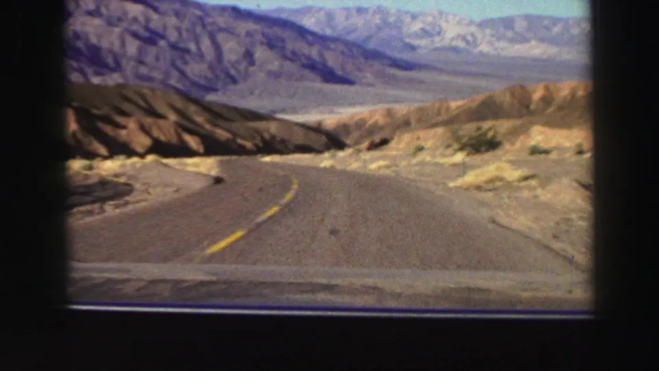 1969 8mm travel view from a car on a curving road through arid mountain country near the Lake Tahoe, California metadata location.