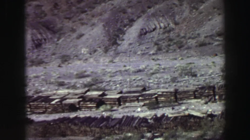 Final sampled frame shows Lake Tahoe rocky terrain, scrub vegetation, and a weathered fence in a faded 8mm home-movie scan.