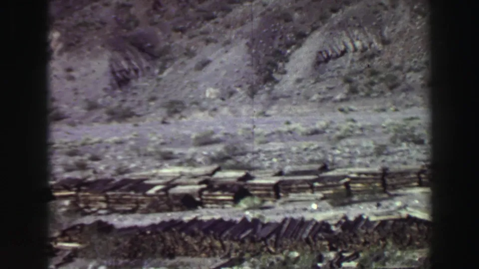Lake Tahoe area 1969 8mm frame showing rugged rocky terrain, distant slope, and dark film gate edges.