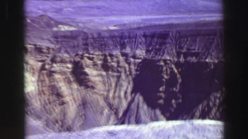 Lake Tahoe area 1969 8mm frame showing a rugged cliff wall, dark rock shadow, and aged purple color shift.