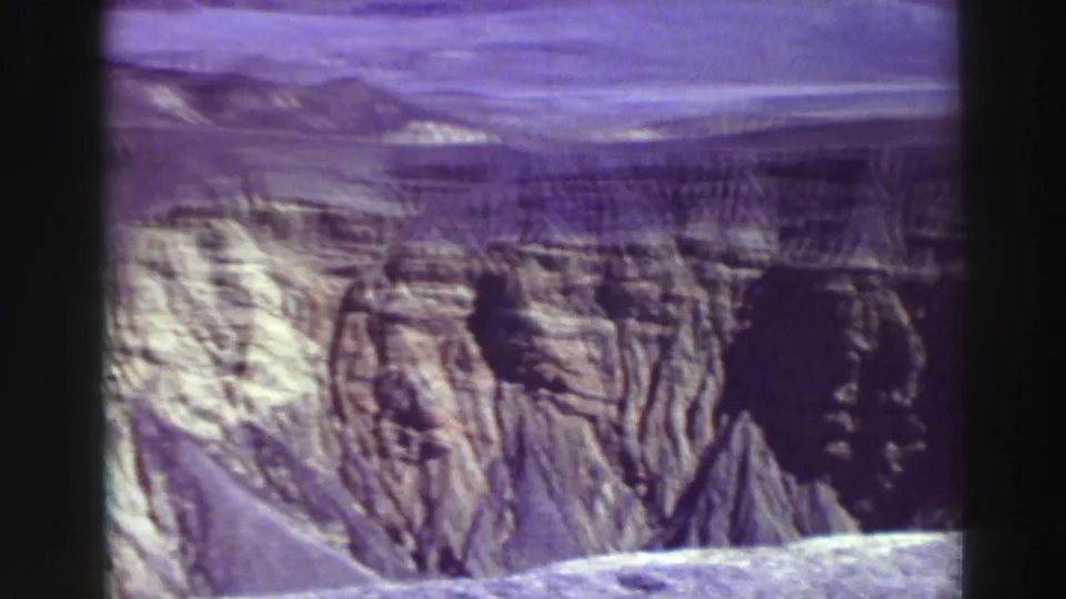 1969 8mm travel frame showing layered canyon walls and rugged pale rock formations in the Lake Tahoe, California metadata context.