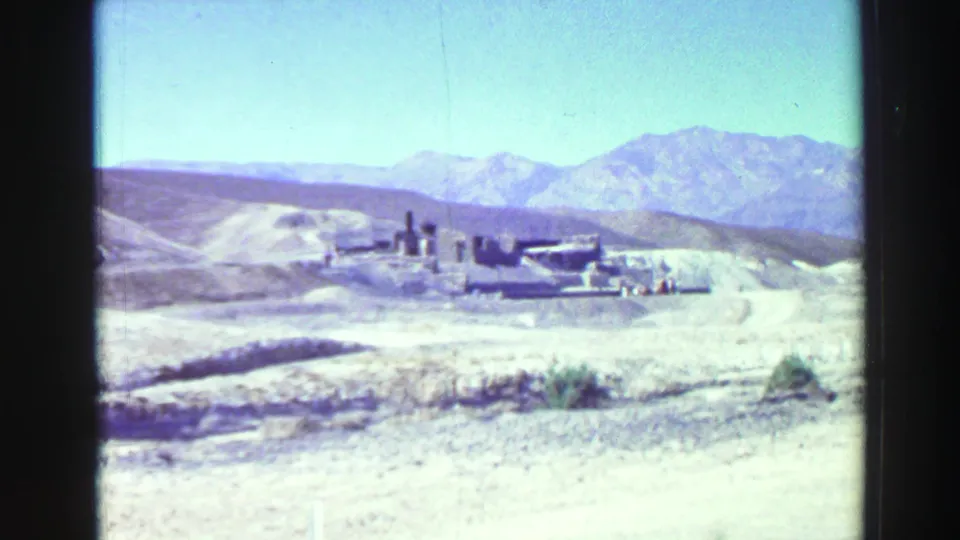 1969 8mm home-movie view near Lake Tahoe showing arid hills, distant mountains, and weathered ruins under bright sky.
