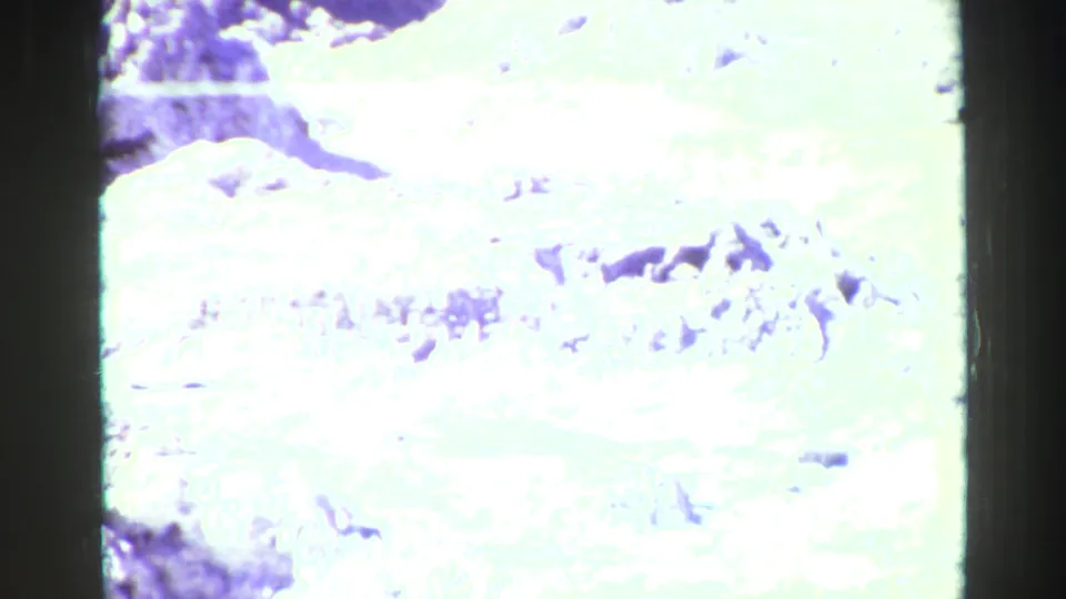 A rugged pale formation, likely part of the Devils Golf Course landscape described in the metadata, is filmed with heavy 8mm overexposure.