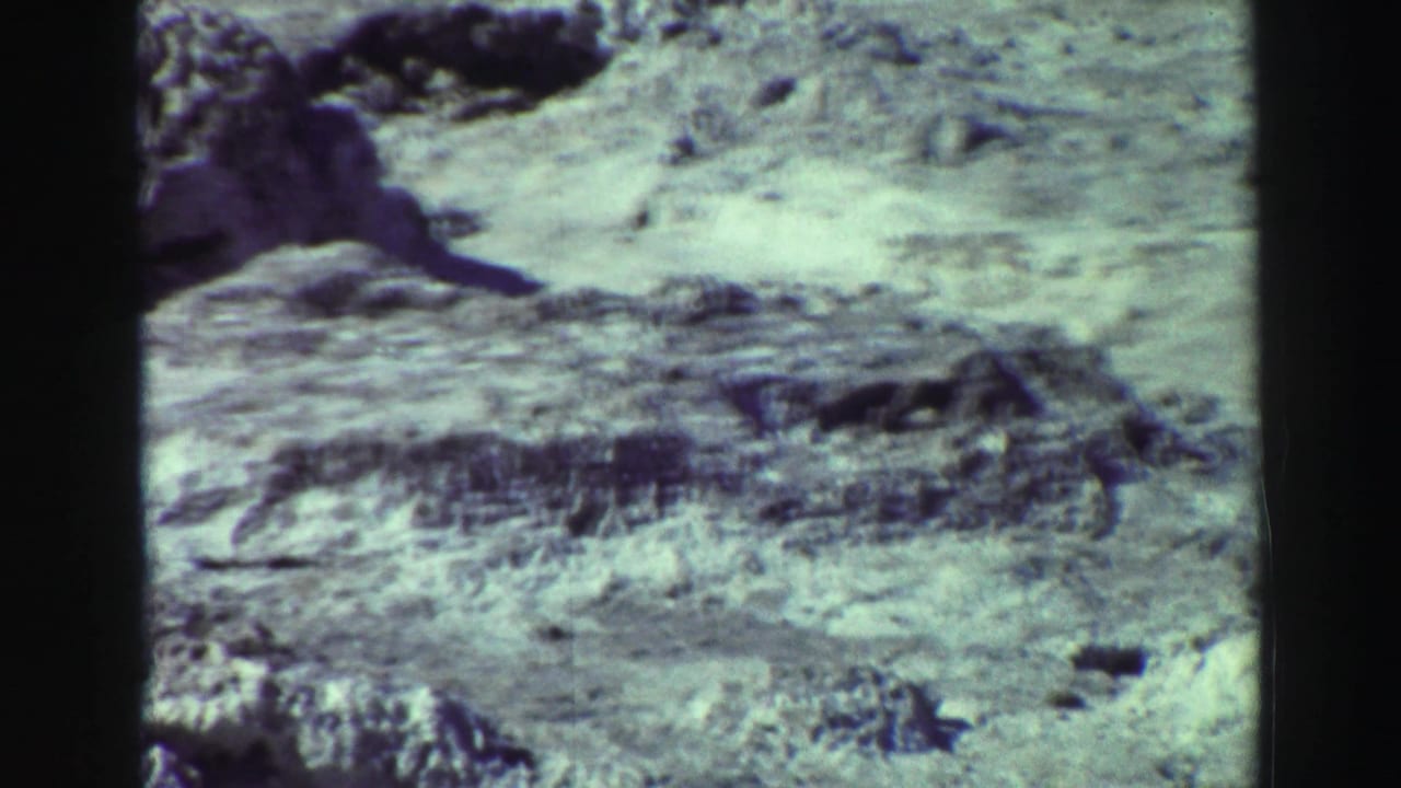 1969 Lake Tahoe-area 8mm frame showing pale rocky ground, shallow eroded ridges, and sparse vegetation.