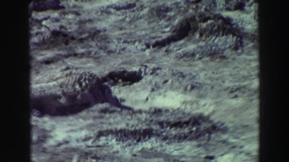 1969 Lake Tahoe-area 8mm frame of rough, pale rock formations and sparse scrub across uneven ground.